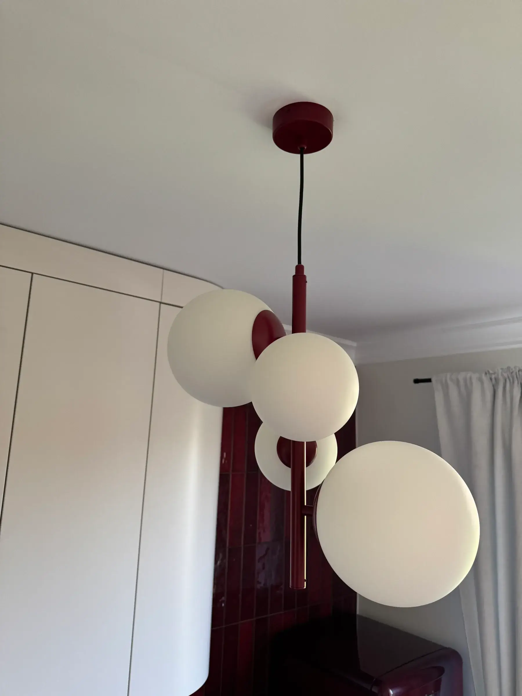 Lampa z mlecznymi kulami na bordowym zawieszeniu